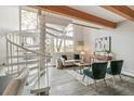 Cozy living room with spiral staircase, bathed in natural light from large windows at 1842 Canyon Blvd # 209, Boulder, CO 80302