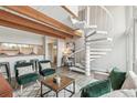 Open living area with wood beam ceilings and a unique spiral staircase at 1842 Canyon Blvd # 209, Boulder, CO 80302