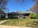 Classic brick house featuring a well-maintained lawn and updated windows under a clear blue sky at 701 S Clayton St, Denver, CO 80209
