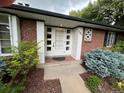 Charming brick home featuring a well-manicured garden and stylish, glass-accented front door at 701 S Clayton St, Denver, CO 80209
