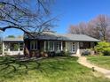 Charming brick home featuring manicured front lawn and inviting front entrance with updated windows at 701 S Clayton St, Denver, CO 80209