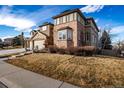 A low angle shows the two-story home with a three-car garage, fountain and winter lawn at 301 Amethyst Way, Superior, CO 80027