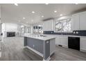 Open kitchen with white cabinets, gray island, and stainless steel appliances, connected to living area at 301 Amethyst Way, Superior, CO 80027