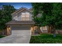 Charming two-story home with a well-manicured lawn, mature trees, and a two-car garage at 10707 Jordan Ct, Parker, CO 80134