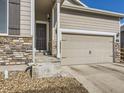 Close-up of the home's entrance with a two-car garage and a stone facade at 529 Vista Blvd, Lochbuie, CO 80603