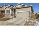 Inviting home with a two-car garage, complemented by stone accents and a landscaped yard at 529 Vista Blvd, Lochbuie, CO 80603