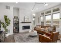 Bright living room boasts modern fireplace with white brick, hardwood floors, and ample natural light at 11027 Sunshimmer Cir, Parker, CO 80134