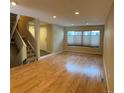 Bright living room featuring wood floors, a large window, and staircase access to the upper level at 935 N Pennsylvania St # 3, Denver, CO 80203