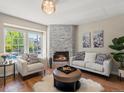 Bright living room featuring a stone fireplace, hardwood floors, and comfortable seating at 9676 W Chatfield Ave # B, Littleton, CO 80128