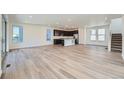 Spacious living and kitchen area with hardwood floors, modern lighting, and large windows at 3147 S Russell St, Morrison, CO 80465