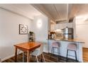 Bright dining area featuring a wooden table, modern chairs, and a breakfast bar adjoining the kitchen at 1265 Race St # 408, Denver, CO 80206