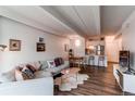 Living room with couch, wood floors, and bar top with kitchen access at 1265 Race St # 408, Denver, CO 80206
