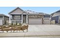 Inviting exterior showcasing a modern home with solar panels, stone accents, three-car garage and stylish neutral color palette at 6711 Fraser Cir, Frederick, CO 80530