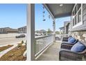 Covered front porch with comfortable wicker seating and views of the street at 6711 Fraser Cir, Frederick, CO 80530