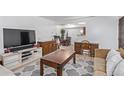 Open-concept living room featuring modern furniture and an adjacent dining area at 381 S Ames St # B103, Lakewood, CO 80226