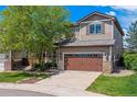 Charming two-story home featuring well-maintained landscaping, a two-car garage and a beautiful tree in the front yard at 10358 Kelliwood Way, Highlands Ranch, CO 80126