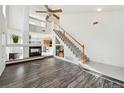 Bright living room featuring a cozy fireplace, stairs, and wood-look flooring, providing ample space at 4865 Gibraltar St, Denver, CO 80249