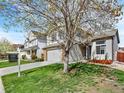 Attractive home boasts a well-kept lawn, brick accents, two-car garage and welcoming front entrance at 718 Fairhaven St, Castle Rock, CO 80104