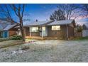 Attractive brick home featuring a covered porch and mature trees at 9360 Lowell Blvd, Westminster, CO 80031