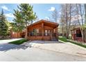 Cozy log cabin-style house featuring a covered porch, natural landscaping, and a peaceful atmosphere at 85 Revett Dr # 66, Breckenridge, CO 80424