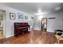 Large living area with hardwood floors, a decorative piano, and ample space for furnishings at 1215 S Ivanhoe Way, Denver, CO 80224