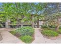 View of the condo from the street and a walking path through a landscaped yard at 695 Manhattan Dr # 109, Boulder, CO 80303