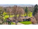 Striking aerial view of a well-maintained single story home with lush green lawn backing up to a manicured golf course at 16 Wedge Way, Littleton, CO 80123