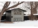 Gray house with black accents, covered carport, and snowy yard at 860 S Quivas St, Denver, CO 80223