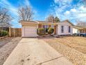 Charming home featuring brick and vinyl siding, a well-manicured lawn, and an attached garage at 2663 S Laredo St, Aurora, CO 80013