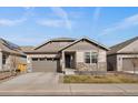 Inviting single-story home showcasing a well-maintained front lawn, stone accents, and a two-car garage at 8390 S Cody Way, Littleton, CO 80128