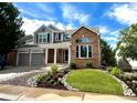 Charming home with brick and siding exterior, featuring a well-maintained lawn and attractive rock landscaping at 787 Huntington Pl, Highlands Ranch, CO 80126