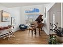 Bright living room with a vaulted ceiling, grand piano, large window, and hardwood floors at 787 Huntington Pl, Highlands Ranch, CO 80126