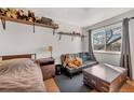 This bedroom has multiple shelves, a futon, a window for natural light, and carpeted floors at 2557 S Dover St # 68, Lakewood, CO 80227