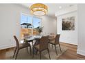 Bright dining room featuring a modern chandelier, stylish table setting, and large window at 3432 W 25Th Ave, Denver, CO 80211