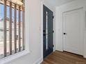 Clean and modern entryway with a dark front door, white walls, and wood floors at 3432 W 25Th Ave, Denver, CO 80211