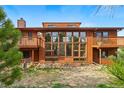 Backyard view of multi-level cedar home with balconies and large windows at 2100 Bibles Hill Dr, Franktown, CO 80116