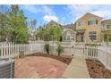 Private backyard featuring a stone patio, white picket fence, and well-manicured lawn, perfect for outdoor entertaining at 843 Snowberry St, Longmont, CO 80503