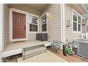 Inviting covered front porch with neutral siding, contrasting trim, and convenient utility access at 843 Snowberry St, Longmont, CO 80503