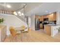 Open-concept kitchen with stainless steel appliances, light wood cabinets, and a dining area, perfect for Gathering gatherings at 843 Snowberry St, Longmont, CO 80503