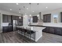 Spacious kitchen featuring a large island, modern stainless steel appliances, and sleek pendant lighting at 5290 Silver Hare Ct, Castle Rock, CO 80104