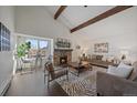 Bright living room with vaulted ceilings, exposed beams, stone fireplace, and large windows at 4068 S Atchison Way # 301, Aurora, CO 80014