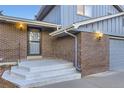 Welcoming front entrance featuring a brick facade and covered porch at 7380 Tabor St, Arvada, CO 80005