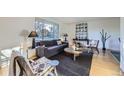 Bright living room with hardwood floors, a large window, and modern furnishings at 7380 Tabor St, Arvada, CO 80005