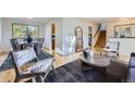 Open-concept living space featuring hardwood floors, comfortable seating, and natural light at 7380 Tabor St, Arvada, CO 80005