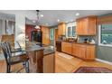 Well-lit kitchen featuring wooden cabinets, granite countertops, and modern appliances at 1161 S Johnson Way, Lakewood, CO 80232