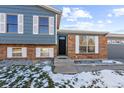 Brick and gray siding home with a black front door and small steps leading to the entrance at 3124 W 9Th Avenue Pl, Broomfield, CO 80020