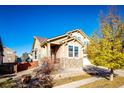 Two-story house with stone and siding exterior, attached garage, and landscaping at 17725 E 99Th Ave, Commerce City, CO 80022