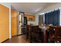 The kitchen features stainless steel appliances, a dining table, and wood cabinets at 4210 E 100Th Ave # 478, Thornton, CO 80229
