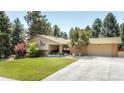 Ranch style home with brick facade, attached garage, and landscaped lawn at 4600 W Princeton Ave, Denver, CO 80236