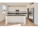 Modern kitchen with white cabinets, stainless steel appliances, granite countertops, and a center island at 11008 Snowdon St, Parker, CO 80134